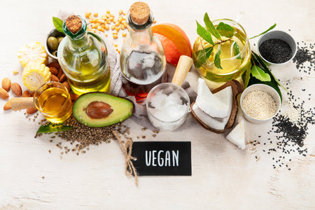 Avocado, almonds, seeds, linseeds, olives and oils on a light background, top view. Alternative oils concept.の写真素材