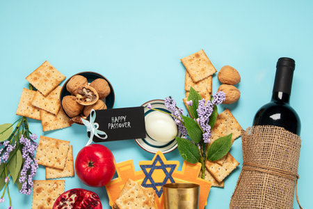 Passover celebration concept. Matzah, red kosher walnut and spring beautiful flowers on a blue background. Traditional ritual Jewish bread. Copy space.の写真素材