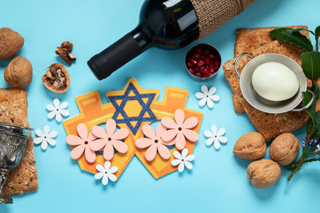 Passover celebration concept. Matzah, red kosher walnut and spring beautiful flowers on a blue background. Traditional ritual Jewish bread.の写真素材