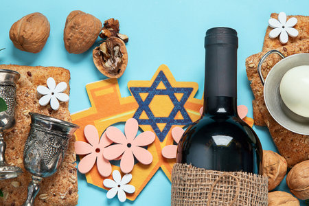 Passover celebration concept. Matzah, red kosher walnut and spring beautiful flowers on a blue...