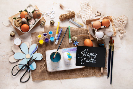 Happy Easter, painting eggs. Paints, pens, decorations for coloring eggs for holiday on a white background. Top view.の写真素材