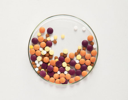 Various colorful pills in petri dish isolated on white, top view. Healthcare support. Pharmacy lab and pharmaceutical research concept. Copy space.の写真素材