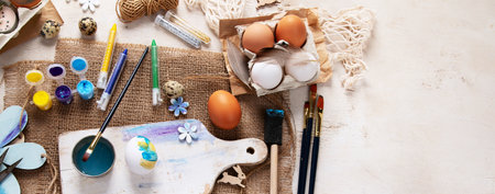Happy Easter, painting eggs. Paints, pens, decorations for coloring eggs for holiday on a white background. Top view. Panorama with copy space.の写真素材