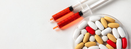 Various colorful pills in petri dish isolated on white, top view. Healthcare support. Pharmacy lab and pharmaceutical research concept. Panorama with copy space.の写真素材
