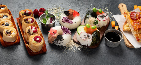 Hybrid trendy food on dark background. Sushi roll pancake, donut sushi, pizza with pasta. Copy spaceの写真素材