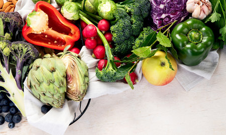 Table with vegetables on a light wood background. Pepper, cabbage, broccoli, radish, garlic. Healthy eating concept. Top view, copy spaceの写真素材