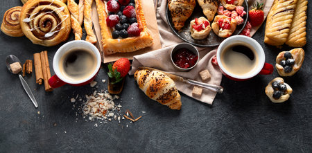 Different tasty freshly baked pastries on dark background. Top view. Panorama with copy space.の写真素材
