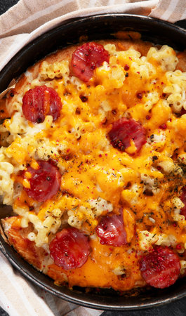 Trendy hybrid food. Mac and cheese pizza on dark background. Top view, copy spaceの写真素材