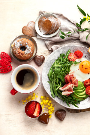 Breakfast served with coffee, fresh bakery, eggs, salad, meat and fruits. Holiday concept. Top view.の写真素材
