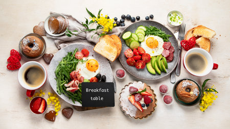 Breakfast served with coffee, fresh bakery, eggs, salad, meat and fruits. Holiday concept. Top view.の写真素材