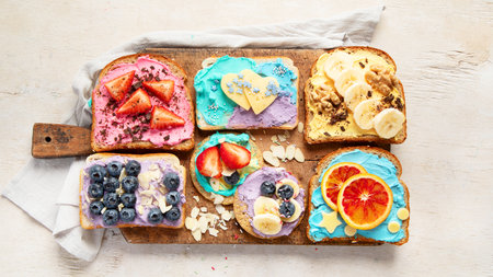 Sweet breakfast. Colorful toasts with fruits and berries. Children's food concept. Top viewの写真素材