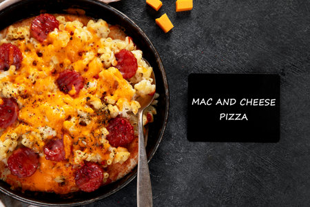 Trendy hybrid food. Mac and cheese pizza on dark background. Top viewの写真素材