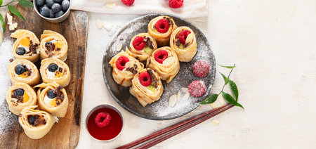 Asian sweet sushi pancake. Rolls with cream cheese berry and fruits. Top view, copy spaceの写真素材