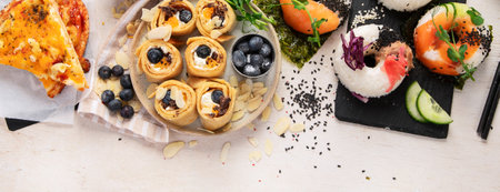 Trend hybrid food. Japanese Asian cuisine. Sushi donuts, sweet sushi pancakes and sauces on a light background. Top view. Panorama with copy space.の写真素材