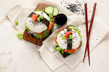 Hybrid modern food. Sushi burger with salmon, white rice, avocado, cucumber. Top viewの写真素材