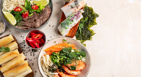 Assorted Asian meal, vietnamese food. Pho bo, noodles, spring rolls, sauces. Top view. Panorama with copy space.の写真素材