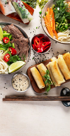 Assorted Asian meal, vietnamese food. Pho bo, noodles, spring rolls, sauces. Top view. Copy space.の写真素材