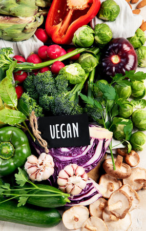 Table with vegetables on a light wood background. Pepper, cabbage, broccoli, radish, garlic. Healthy eating concept. Top viewの写真素材