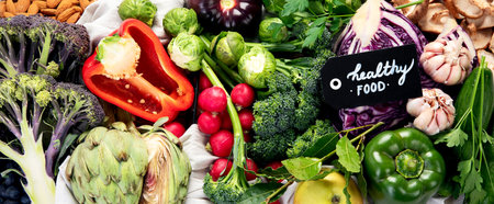 Table with vegetables on a light wood background. Pepper, cabbage, broccoli, radish, garlic. Healthy eating concept. Top view, bannerの写真素材