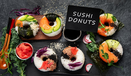 Sushi donuts on a dark background. Hybrid trend food. Top viewの写真素材