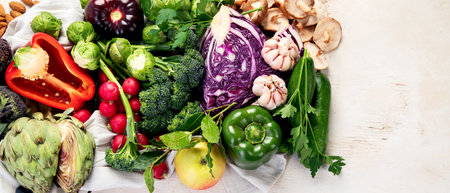 Table with vegetables on a light wood background. Pepper, cabbage, broccoli, radish, garlic. Healthy eating concept. Top view, copy space, bannerの写真素材