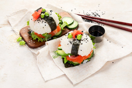 Hybrid modern food. Sushi burger with salmon, white rice, avocado, cucumberの写真素材