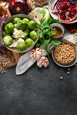Vegan food. Pepper, broccoli, cabbage, garlic, mushrooms, pomegranate on a dark background. Top view, copy spaceの写真素材