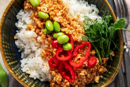 Vegan food. Soy meat, white rice, beans, red pepper on light wooden background. Top viewの写真素材