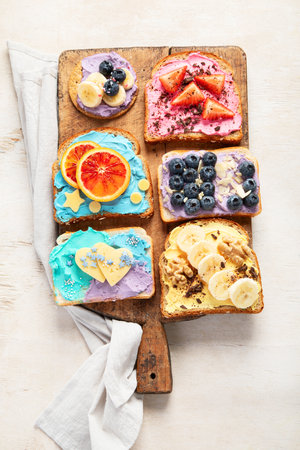 Sweet breakfast. Colorful toasts with fruits and berries. Children's food concept. Top viewの写真素材