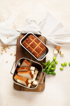Soy food. Baked tofu cheese on a board, soybeans. Vegan product. Top viewの写真素材