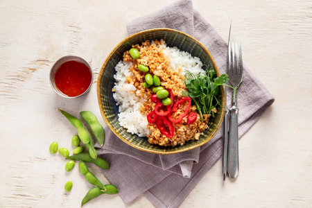 Vegan food. Soy meat, white rice, beans, red pepper on light wooden background. Top viewの写真素材