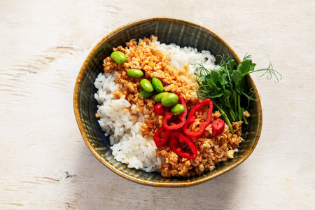 Vegan food. Soy meat, white rice, beans, red pepper on light wooden background. Top viewの写真素材