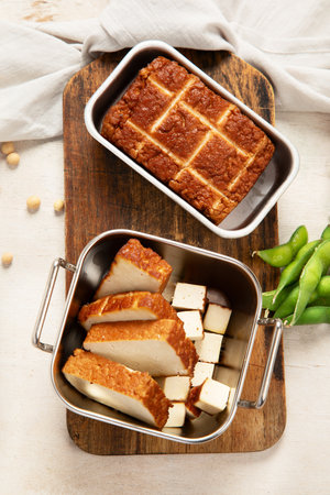 Soy food. Baked tofu cheese on a board, soybeans. Vegan product. Top viewの写真素材