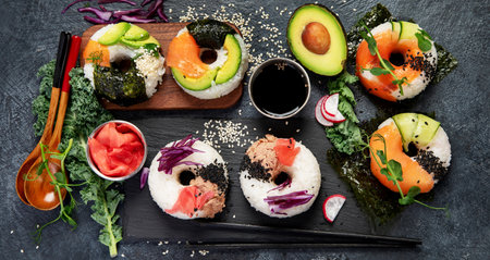 Sushi donuts on a dark background. Hybrid trend food. Top view, bannerの写真素材