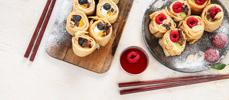 Asian sweet sushi pancake. Rolls with cream cheese berry and fruits. Top view, copy spaceの写真素材