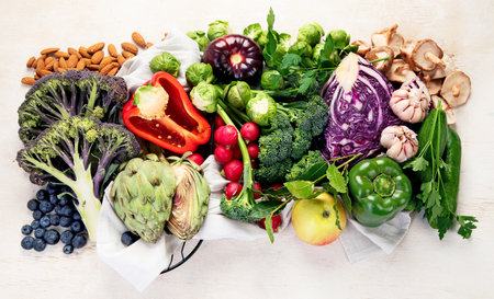 Table with vegetables on a light wood background. Pepper, cabbage, broccoli, radish, garlic. Healthy eating concept. Top viewの写真素材