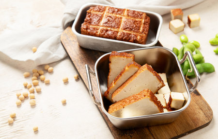 Soy food. Baked tofu cheese on a board, soybeans. Vegan product. Copy spaceの写真素材