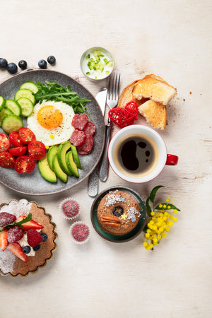 Breakfast served with coffee, fresh bakery, eggs, salad, meat and fruits. Holiday concept. Top view.の写真素材