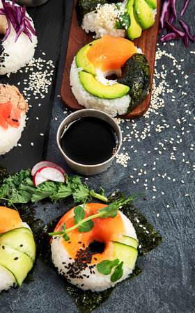 Sushi donuts on a dark background. Hybrid trend food. Top viewの写真素材