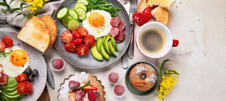Breakfast served with coffee, fresh bakery, eggs, salad, meat and fruits. Holiday concept. Top view.の写真素材