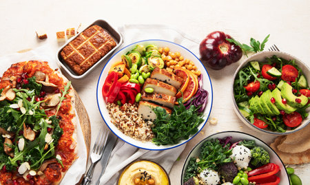 Vegetarian food concept. Set of healthy vegetarian food, salad, avocado, pizza and buddha bowl on a light background, top view. Copy space.の写真素材