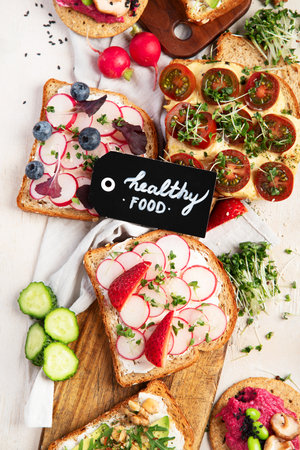Breakfast with vegetables. toasts, tomato, cucumber, radish, avocado. Vegan healthy food concept. Top viewの写真素材
