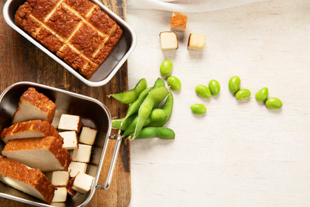 Soy food. Baked tofu cheese on a board, soybeans. Vegan product. Top view, copy spaceの写真素材