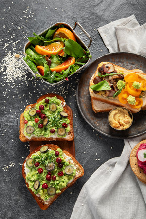Vegan toast with avocado,mushroom and fresh salad on dark background. Vegetarian food concept. Top viewの写真素材