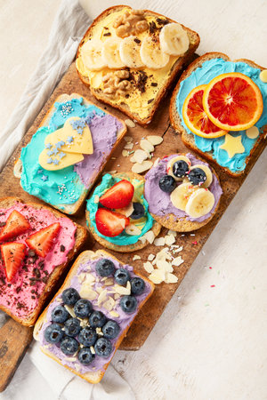 Sweet breakfast. Colorful toasts with fruits and berries. Children's food concept. Top viewの写真素材