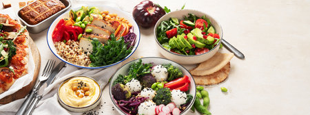 Vegetarian food concept. Set of healthy vegetarian food, salad, avocado, pizza and buddha bowl on a light background, top view. Panorama with copy space.の写真素材