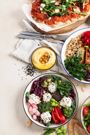 Vegetarian food concept. Set of healthy vegetarian food, salad, avocado, pizza and buddha bowl on a light background, top view. Copy space.の写真素材
