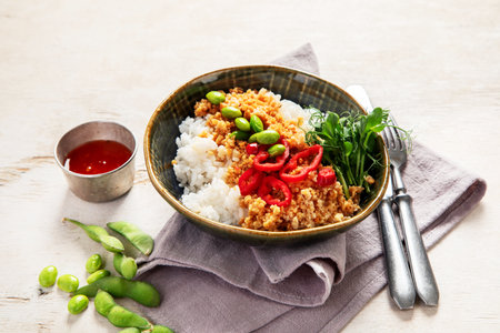 Vegan food. Soy meat, white rice, beans, red pepper on light wooden background. Top viewの写真素材