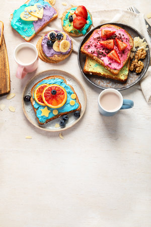 Sweet breakfast with cup of cocoa. Toast with cream cheese, banana, strawberries, blueberries. Top view, copy spaceの写真素材
