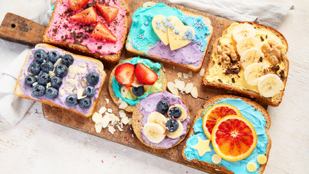 Sweet breakfast. Colorful toasts with fruits and berries. Children's food concept. Top viewの写真素材